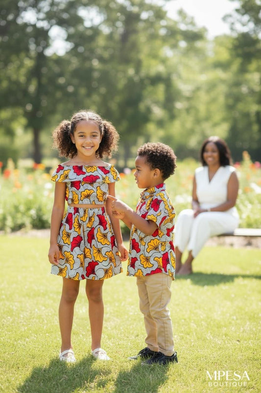 Tenues en wax pour enfants faits main : fille en jupe et crop top, garçon en chemise, mode enfant durable et colorée.