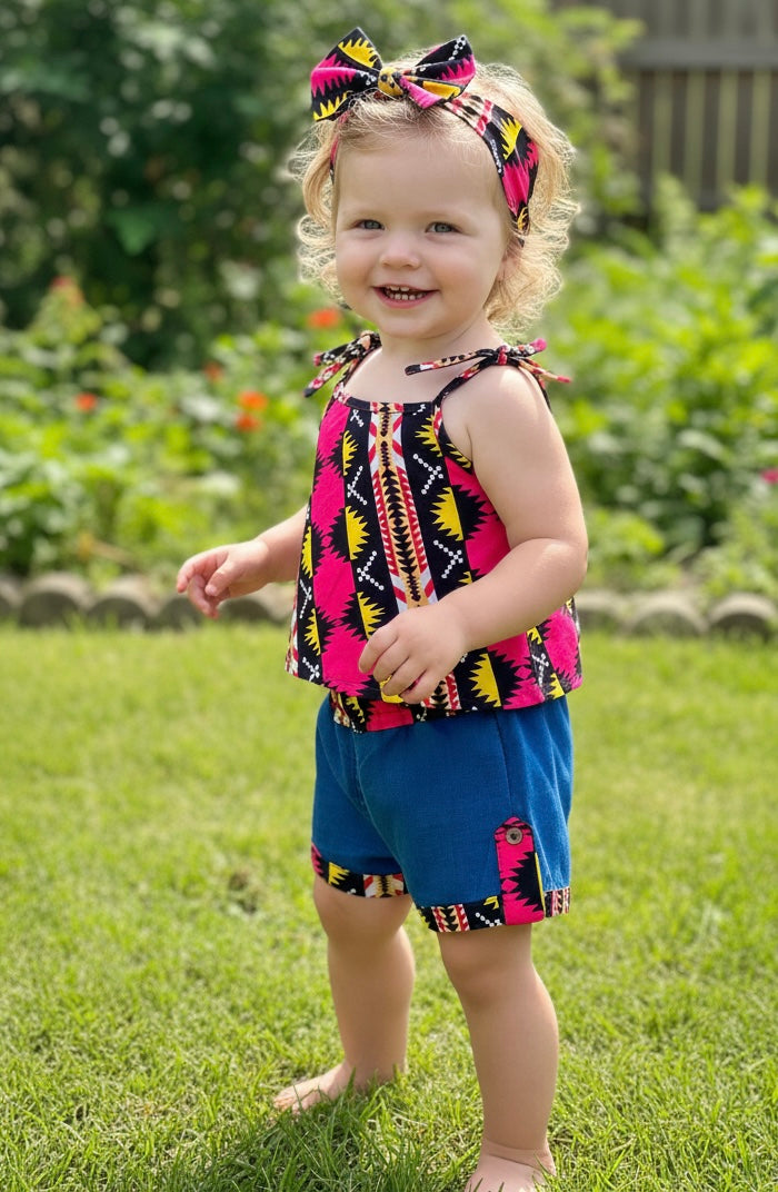 enue estivale pour fille comprenant un short en jean décontracté, un top à bretelles en wax aux motifs africains vibrants, et un bandeau assorti pour un look coordonné et tendance.