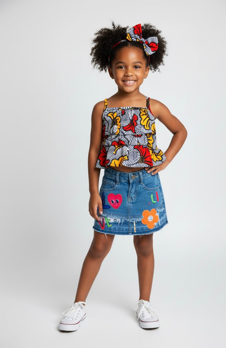 Ensemble fille cérémonie : jupe et top à bretelles en wax fleuri, avec bandeau assorti.