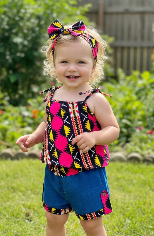 Tenue fille tendance avec short en jean, haut wax coloré et bandeau assorti, idéale pour l’été.