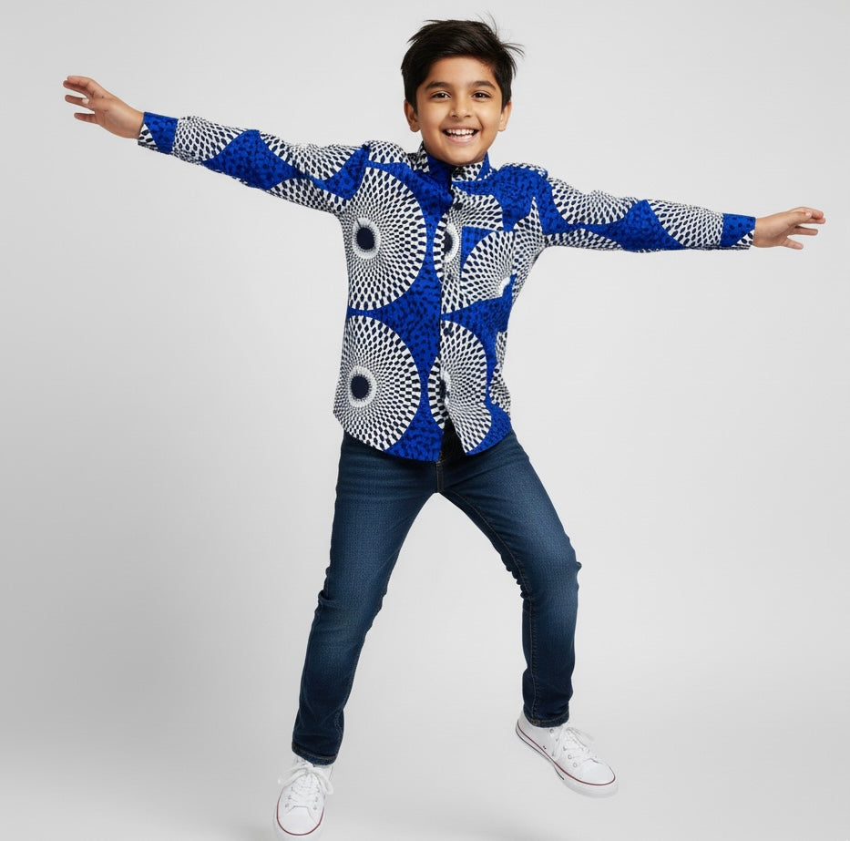 Enfant portant une chemise longue manches deux-en-une en tissu wax coloré, vêtement polyvalent et stylé mêlant tradition et modernité.
