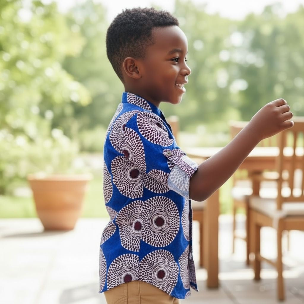 Enfant portant une chemise longue manches deux-en-une en tissu wax coloré, vêtement polyvalent et stylé mêlant tradition et modernité.