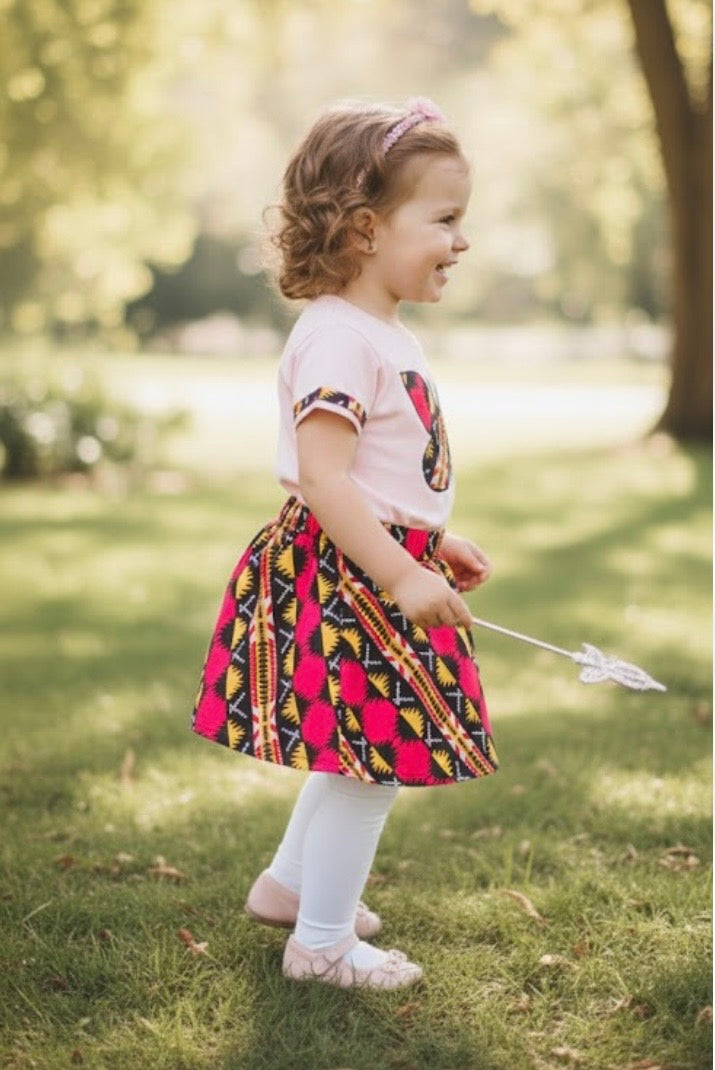 Ensemble artisanal pour fillette 2/3 ans avec jupe en wax et t-shirt rose en coton 100 %, décoré d’un papillon en wax cousu à la main.