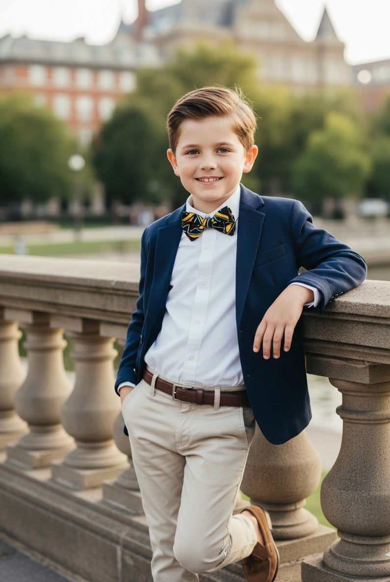 Nœud papillon pour enfant garçon en tissu wax bogolan, aux motifs traditionnels africains. Le wax coloré recouvre entièrement l’élastique, pour un fini élégant et uniforme.