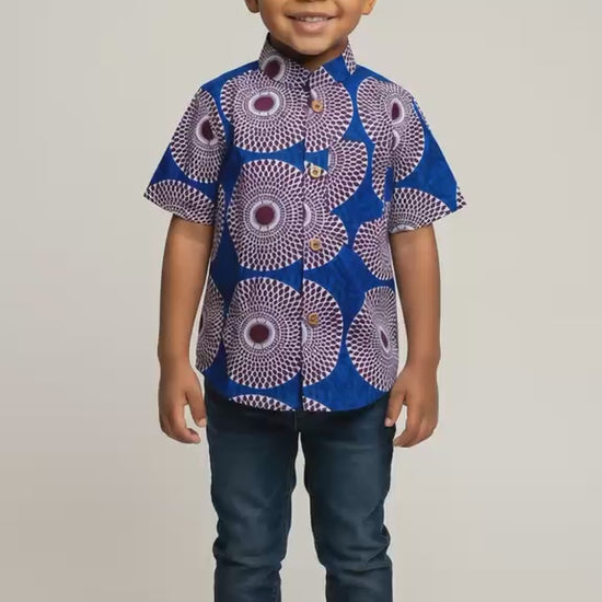 Vidéo d'une chemise enfant en wax aux motifs africains colorés, confectionnée artisanalement pour un style afro moderne unique destiné aux garçons de 2 à 12 ans.
